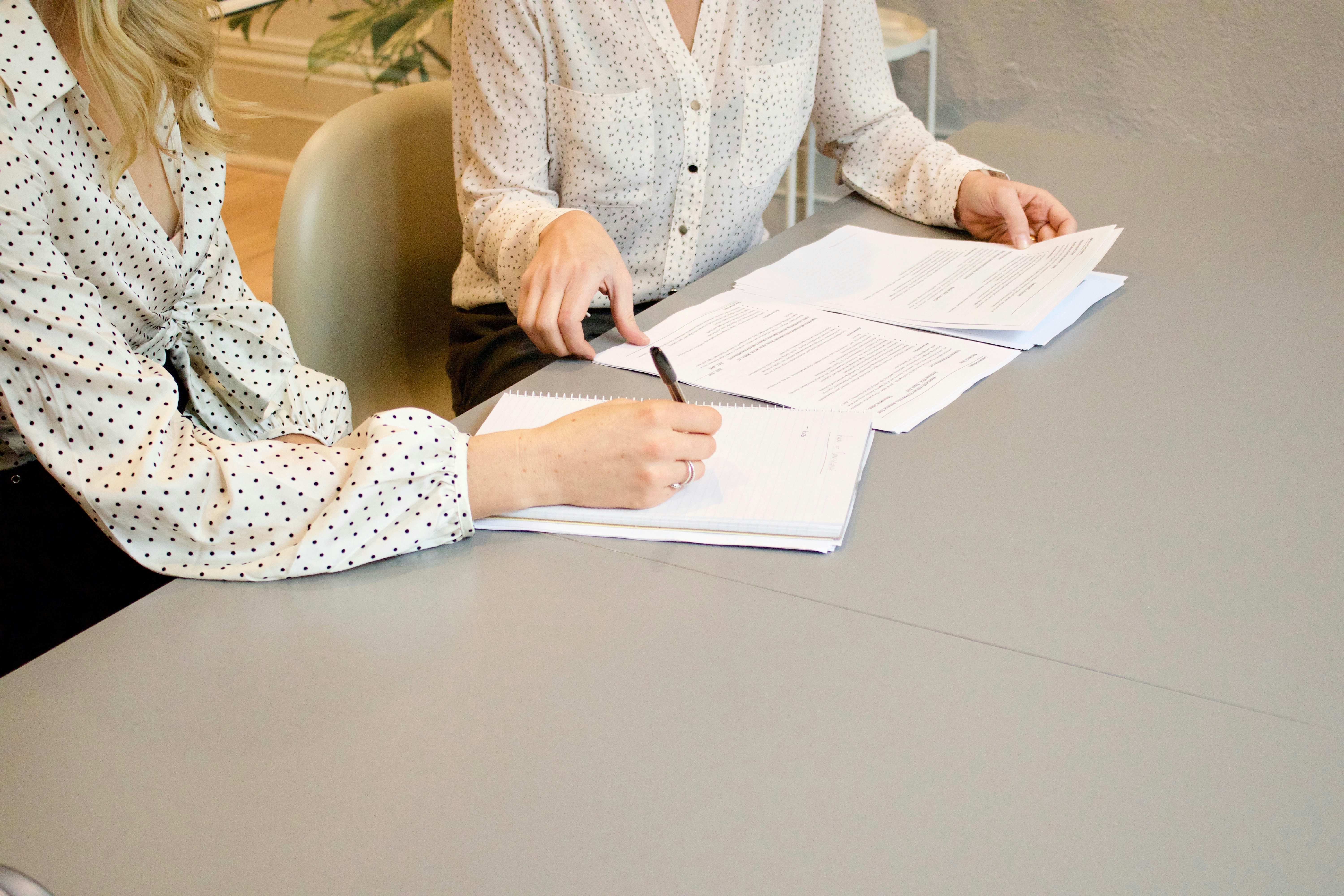2 women signing paper